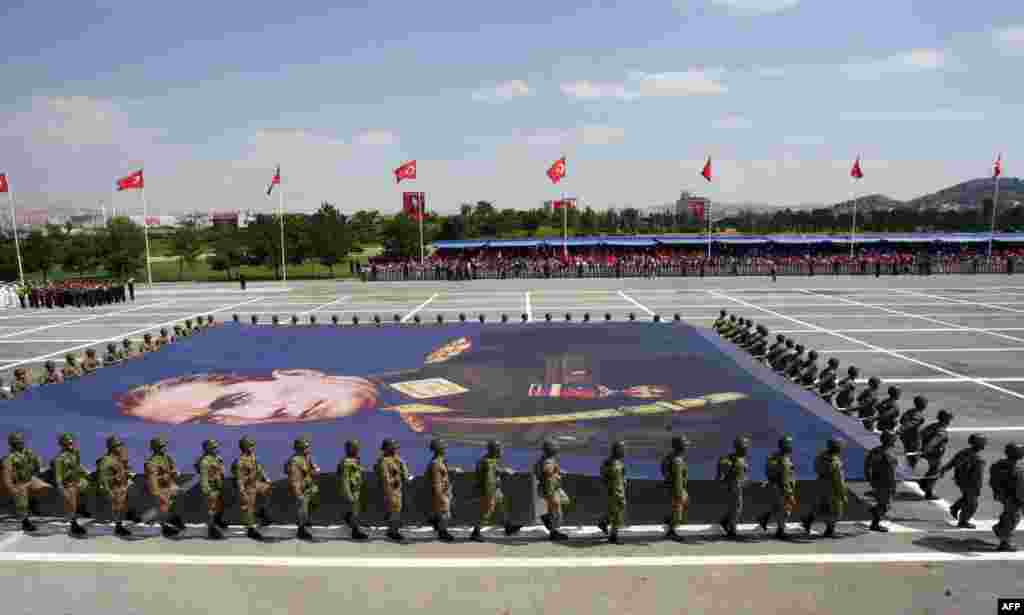Turkish soldiers carry a giant banner bearing a portrait of Mustafa Kemal Ataturk, founder of modern Turkey, during a parade marking the 91st anniversary of Victory Day in Ankara. 