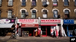 FILE - People walk past the Polish Mleczko delicatessen and restaurant in London, April 5, 2016. Following right-wing election gains, Eurosceptics in Austria and Poland are keeping a close eye on Britain’s June 23rd referendum to stay or quit the European Union.