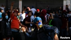 Opposition demonstrators throw stones at police during a protest against Venezuela's President Nicolas Maduro's government in Caracas, Feb. 12, 2014.
