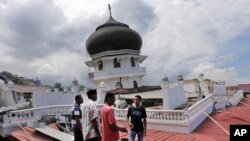 Warga memeriksa sebuah masjid yang amblas karena gempa di Pidie Jaya, Aceh (7/12). (AP/Heri Juanda)