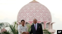 Presiden Filipina Rodrigo Duterte (kiri) bersama Perdana Menteri Malaysia Najib Razak di Putrajaya, Malaysia, 10 November 2016 (AP Photo/Lim Huey Teng).