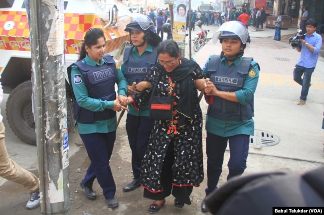 Police in Dhaka arrest a female BNP activist. After the election schedule was announced in November, about 12,300 opposition party leaders and workers reportedly were arrested. (VOA/Babul Talukder).