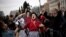People dance and sing during a demonstration to mark International Women's Day in front of the parliament building in Athens, Greece.