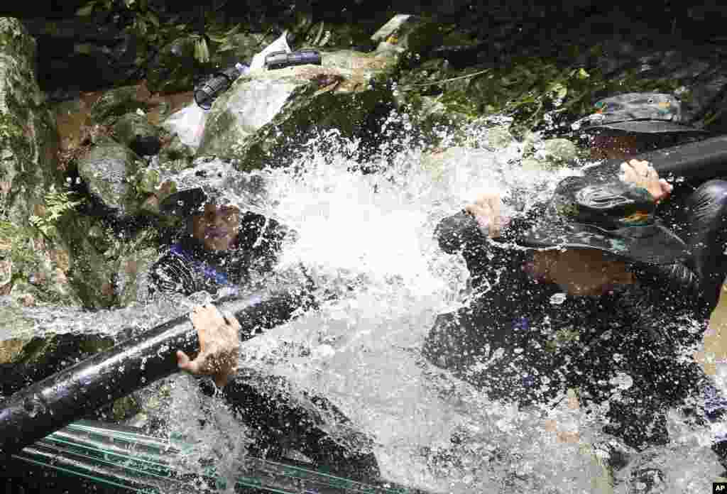 Thai soldiers try to connect water pipes that will help bypass water from entering a cave where 12 boys and their soccer coach have been trapped, in Mae Sai, Chiang Rai province, in northern Thailand, July 7, 2018.