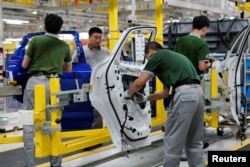 FILE - Employees work at the production line inside the Chery Jaguar Land Rover plant phase 2 after the phase 2 opening ceremony in Changshu, Jiangsu province, China, June 27, 2018.