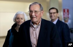 Merrill Newman, center, walks beside his wife Lee, left, and his son Jeffrey after arriving at San Francisco International Airport, Dec. 7, 2013. Newman was detained in North Korea in late October 2013 after a 10-day trip to North Korea.