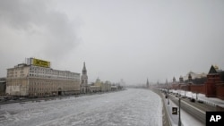 A giant anti-Prime Minister and presidential candidate Vladimir Putin billboard set up by the opposition Solidarity movement on a building, left, which faces the Kremlin, right, is seen in downtown Moscow on February 1, 2012.