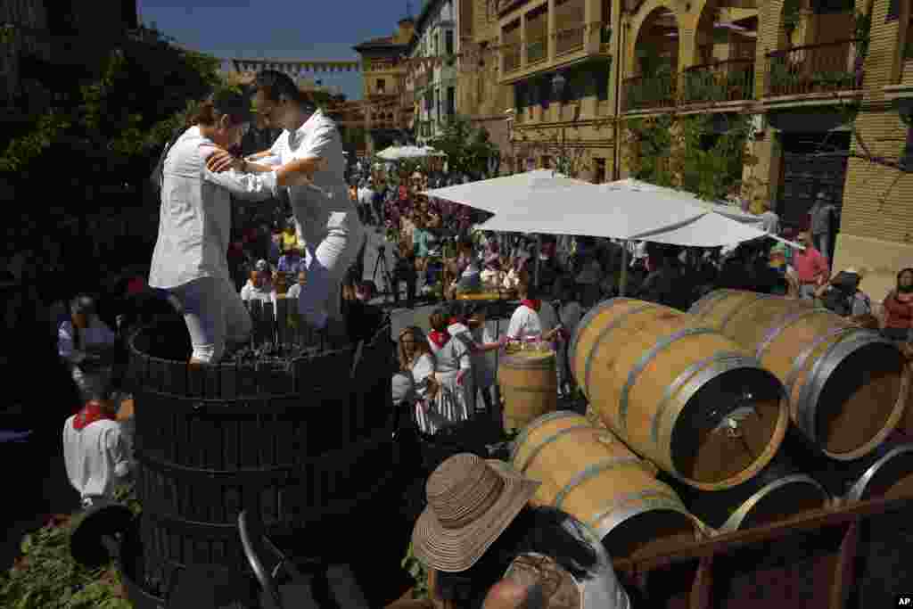 Two teenagers tread the grapes in a oak barrel, during the Wine Harvest Festival, in Olite, northern Spain.
