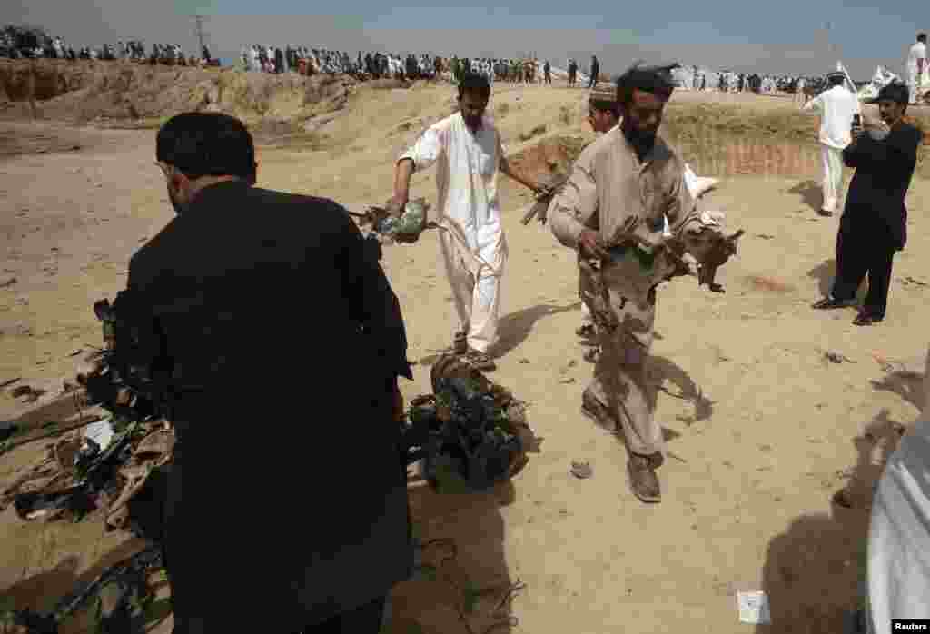 Security officials collect evidence at the site of a bomb attack in Jalozai camp in Nowshera district, northwestern Pakistan, March 21, 2013.
