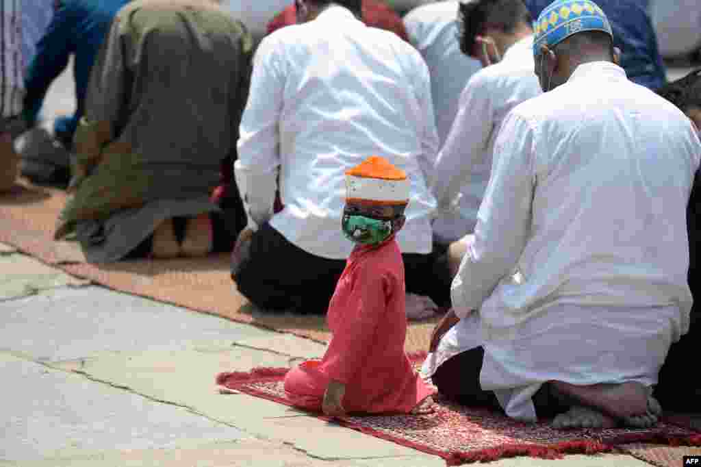 A boy looks back as Muslim devotees offer Jummat-Ul-Vida prayers on the last Friday of the holy month of Ramadan ahead of the Eid al-Fitr, at Mecca Masjid in Hyderabad