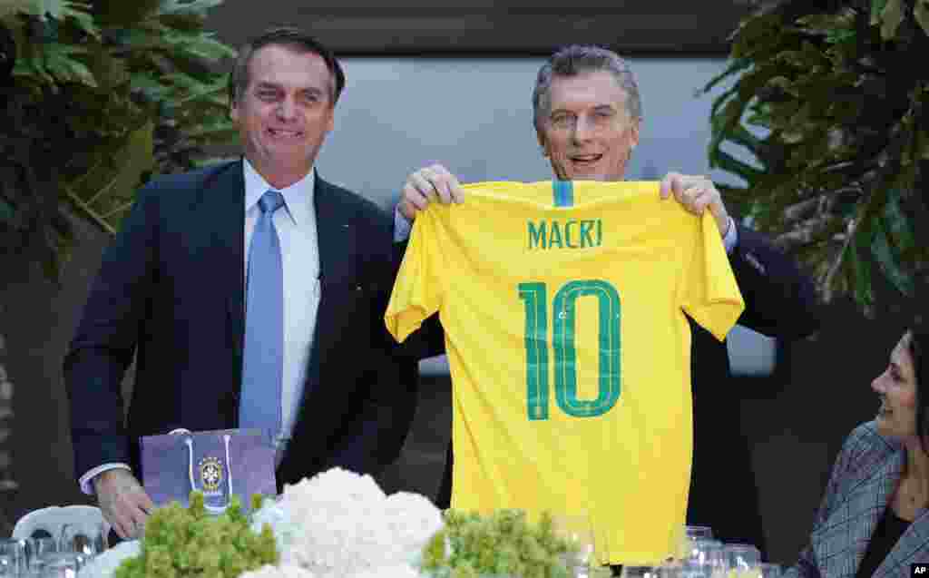 رئیس جمهوری آرژانتین از رئیس جمهوری برزیل، پیراهن شماره ده تیم ملی فوتبال این کشور را هدیه گرفته و به عکاسان نشان می دهد. این دو کشور در مسابقات فوتبال آمریکای جنوبی و جام جهانی رقبای جدی هم هستند.&nbsp;