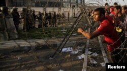 A supporter of the Muslim Brotherhood and ousted Egyptian President Mohamed Morsi shouts slogans in front of army soldiers and riot police, during a protest against the military near Rabaa al-Adawiya square in Cairo, Oct. 4, 2013.