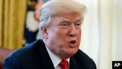 FILE - President Donald Trump speaks with reporters in the Oval Office of the White House in Washington, Dec. 22, 2017.