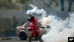 Một người biểu tình ném trả lựu đạn cay về phía cảnh sát trong cuộc biểu tiìn ở Bangkok, Thái Lan, 26/12/13