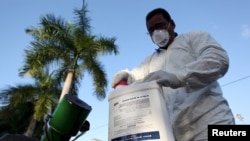 FILE - A health worker prepares insecticide before fumigating a neighborhood in San Juan, Puerto Rico, Jan. 27, 2016.