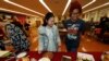 FILE - Miaofan Chen, left, works her way through the dessert choices along with Thandi Glick during a potluck meal for Chinese exchange students and their host families in Denver, Jan. 27, 2017.