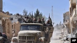 FILE - Syrian soldiers celebrate their victory against the Islamic State group in Qaryatain, Syria, April 4, 2016. 