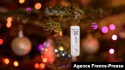 A negative SARS-CoV-2 rapid antigen test used to detect the Covid-19 coronavirus hangs on a Christmas tree in Lausanne, Switzerland..
