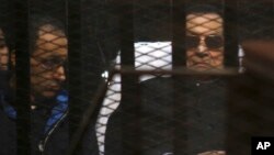 Mantan Presiden Hosni Mubarak (kanan) bersama putranya Gamal Mubarak saat hadir di pengadilan Kairo, Sabtu (29/11).