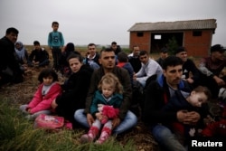 Para pengungsi Suriah yang menyeberangi Sungai Evros, batas negara alami antara Yunani dan Turki, beristirahat di sebuah lapangan sambil menunggu kedatangan polisi untuk membawa mereka ke pusat penerimaan dekat Desa Nea Vyssa, Yunani, 2 Mei 2018.