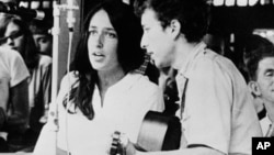 FILE - In this 1963 file photo, Joan Baez and Bob Dylan perform at the Newport Jazz Festival in Newport, R.I. Two years later, at the same festival, Dylan plugged in an electric guitar and shocked the music world.