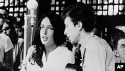 In this 1963 file photo, Joan Baez and Bob Dylan perform at the Newport Jazz Festival in Rhode Island.