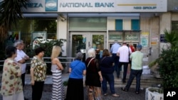 Warga Yunani antri di sebuah ATM di luar sebuah bank yang tutup di Athena, Selasa (30/6).
