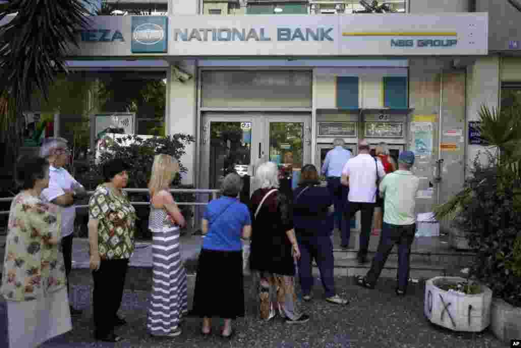 Warga Yunani antre di sebuah ATM di luar sebuah bank yang tutup di Athena, Selasa (30/6).&nbsp;(AP/Thanassis Stavrakis)