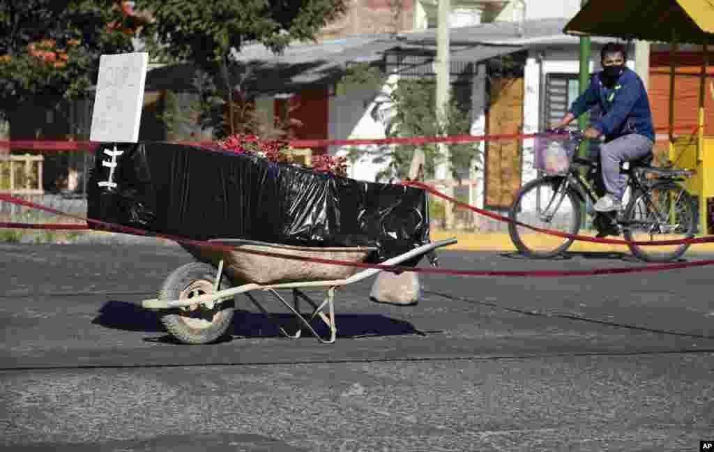 A coffin wrapped in plastic containing the body of an unidentified man, who died last week, sits on a wheelbarrow in the middle of a street in Cochabamba, Bolivia, July 4, 2020. The coffin was placed there by his family to draw attention of the authorities to show that his remains are yet to be collected.