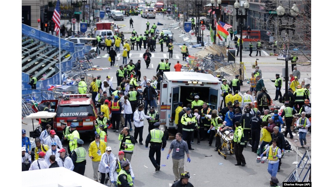 FILE - This April 15, 2013, photo shows medical workers aiding injured people at the finish line of the 2013 Boston Marathon following an explosion.