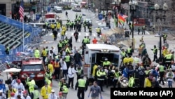 Медики помогают раненым на финишной линии марафона в Бостоне сразу после взрывов, 15 апреля 2013