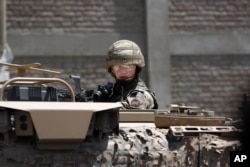 FILE - A US forces soldier guards the site after a suicide bombing attack near Kabul's international airport in Kabul, Afghanistan, May 17, 2015.