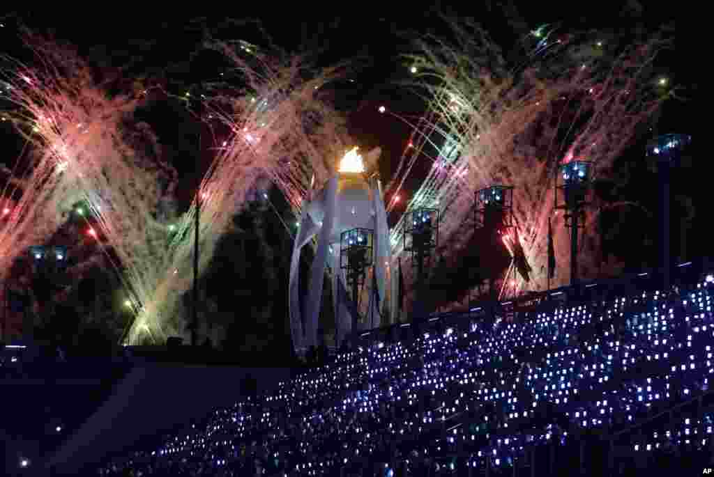 Fireworks explode over the Olympic flame during the closing ceremony of the 2018 Winter Olympics in Pyeongchang, South Korea, Feb. 25, 2018.
