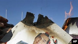 Protesters burn a photo of former Tunisian President Zine el-Abidine Ben Ali during a demonstration in Tunis, January 24, 2011
