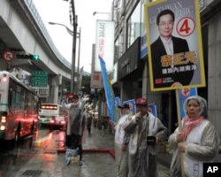 候选人冒雨在街头定点拜票