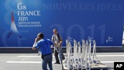 Men work near a G8 backdrop as preparations continue ahead of the G8 summit in Deauville, northern France, May 25, 2011