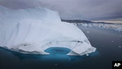 FILE - In this July 19, 2007 file photo, an iceberg is seen melting off the coast of Ammasalik, Greenland. A new assessment of climate change in the Arctic shows the ice in the region is melting faster than previously thought and sharply raises projectio