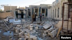 FILE - People gather at the site of a bombing in the city of Ramadi, west of Baghdad, Iraq, Nov. 6, 2014.