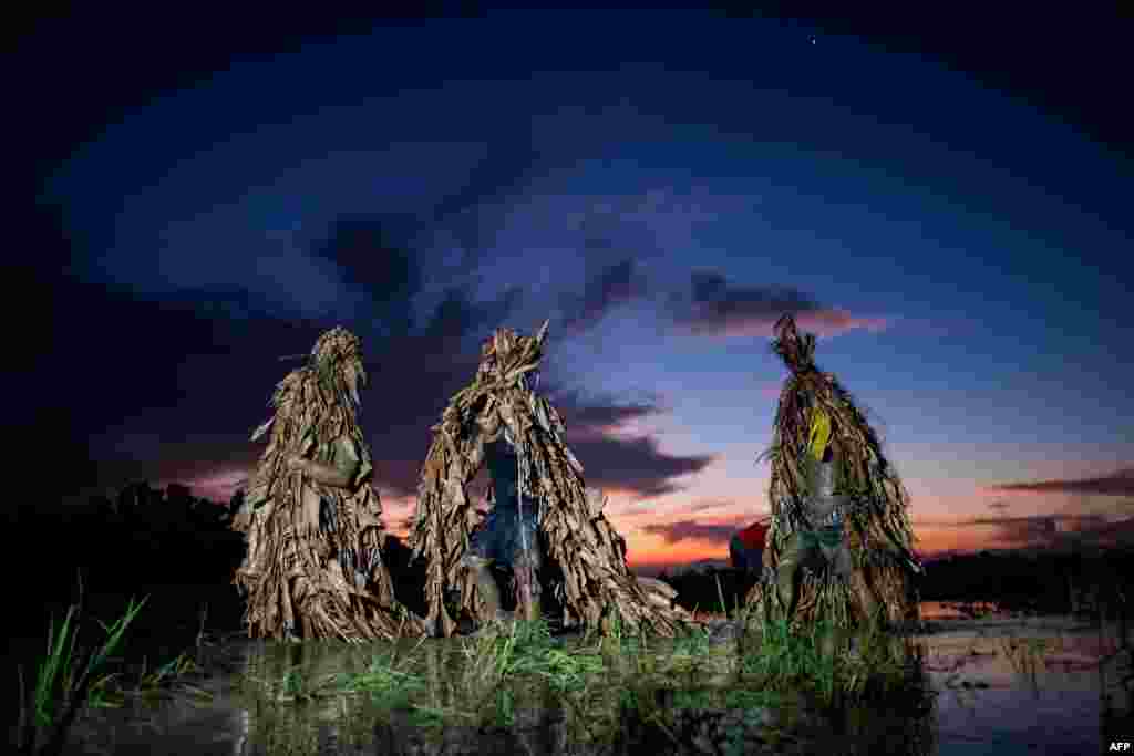 필리핀 마닐라 북부 누에바에시하주에서 세례자 요한 성인을 기념하는 축제가 열린 가운데, 주민들이 전통에 따라 바나나잎으로 만든 옷을 입고 미사에 참가하기 위해 성당으로 향하고 있다.