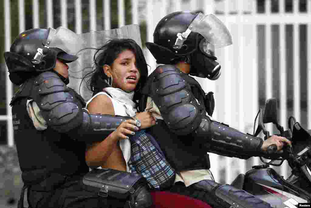 National police detains an anti-government protester during a protest against President Nicolas Maduro's government in Caracas, Venezuela, Mar. 13, 2014.