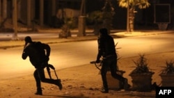 Libyan security forces are seen advancing during clashes with anti-government forces following an attack on a Benghazi police station, early on May 2, 2014. 