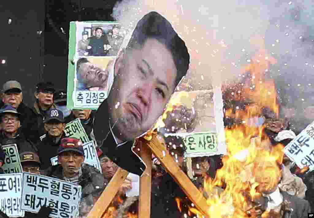 A portrait of North Korean leader Kim Jong Un is burned by protesters during an anti-North Korea rally marking the second anniversary of Kim Jong Il's death, Seoul, Dec. 17, 2013. 