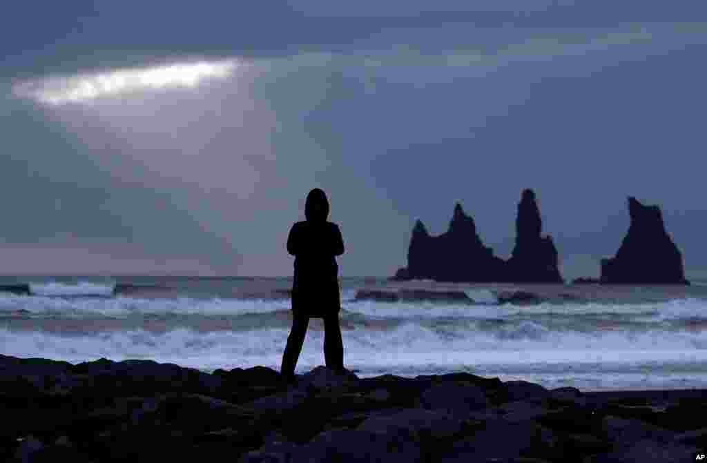 یک زن در دریای سیاه در ویک ایسلند، به نزدیکی&zwnj; آتشفشان کاتلا ایستاده است.&nbsp;