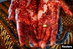 Tangan seorang pengantin di Aceh yang sudah dihias menjelang akad nikah di Banda Aceh, 9 Desember 2012.