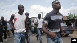 Les jeunes fidèles à l'opposition portent des armes artisanales et une arme à feu, pour former des unités 'd'auto-défense' dans le district de Youpougon à Abidjan, Côte d'Ivoire, février 25, 2011, après le scrutin contesté de novembre 2011. (AP Photo / Emanuel Ekra)