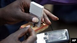 Jeremiah Murimi, a Kenyan electrical engineering student demonstrates how a 'smart charger' connected to a bicycle powers a mobile phone at the University of Nairobi. (File Photo)