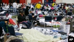 People rest at the George R. Brown Convention Center that has been set up as a shelter for evacuees escaping the floodwaters from Tropical Storm Harvey in Houston, Aug. 29, 2017.