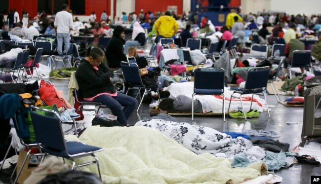 People rest at the George R. Brown Convention Center that has been set up as a shelter for evacuees escaping the floodwaters from Tropical Storm Harvey in Houston on Tuesday, Aug. 29, 2017.