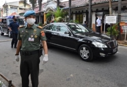 Para petugas keamanan berjaga di dekat mobil kepresidenan yang membawa Presiden Joko Widodo usai membagikan bantuan kepada warga yang terdampak Covid-19, di Jakarta, 18 Mei 2020. (Foto: Adek Berry/AFP)