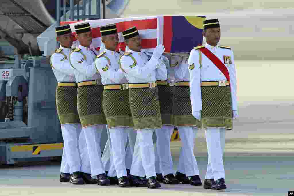 Malaysian Army soldiers carry a coffin containing the body of Mohd Ghafar Abu Bakar, a Malaysia Airlines in-flight supervisor who was among the victims onboard Flight MH17, upon arrival at Kuala Lumpur International Airport in Sepang.